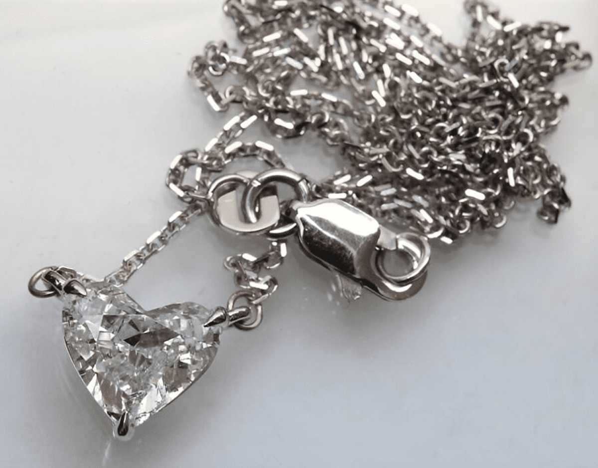 Heart-shaped diamond pendant on silver chain.