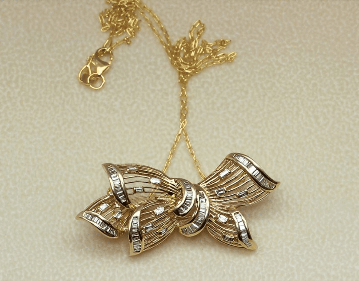 Gold necklace with decorative bow pendant.